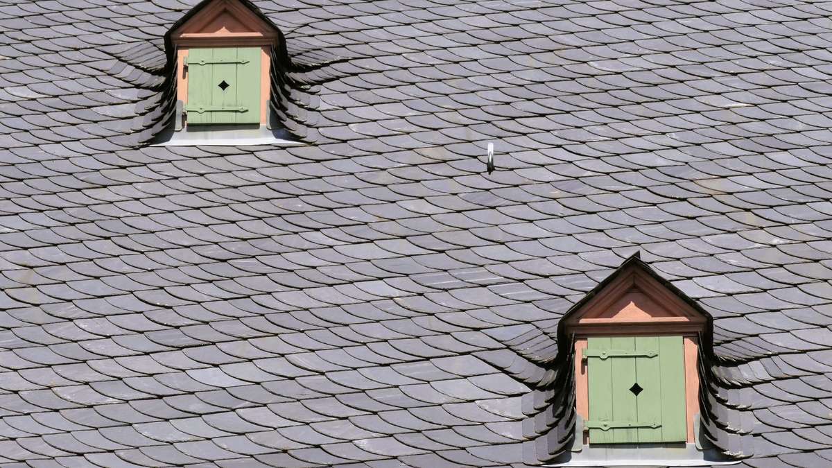 Toiture en ardoise naturelle avec lucarnes et zinguerie sur une maison de montagne
